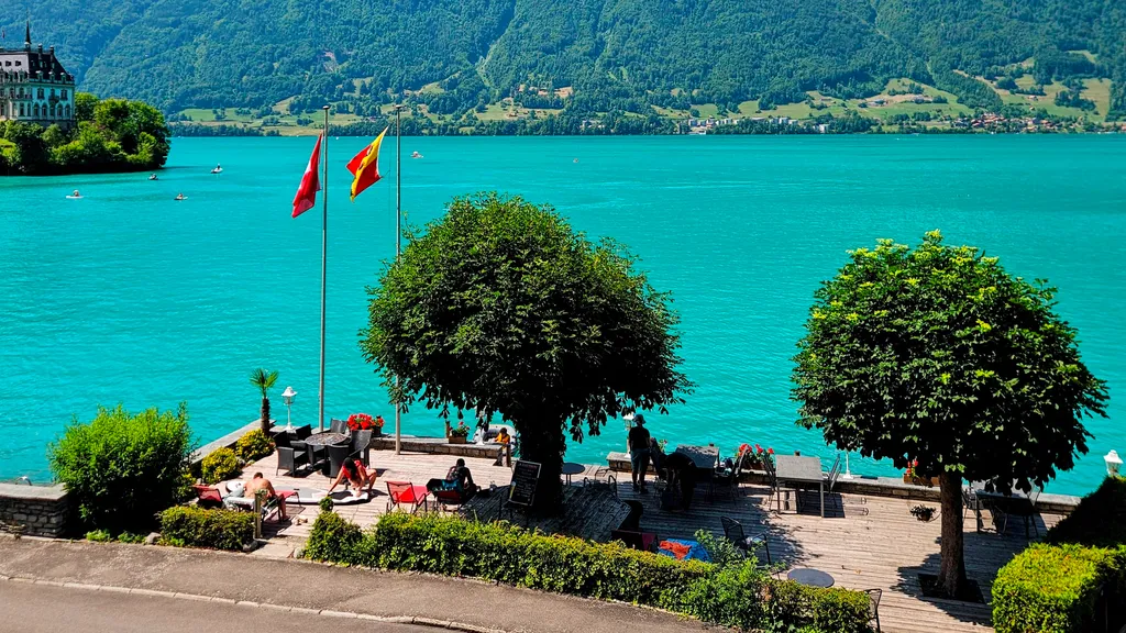 Sunny Sip & Dip lakeside terrace with cafe tables and turquoise Lake Brienz views